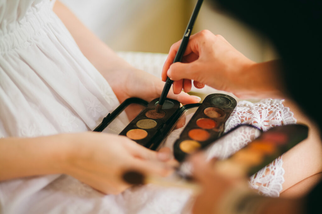 Palette de maquillage et pinceau utilisés pour préparer le look de la mariée