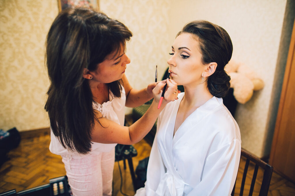 Maquilleuse appliquant le maquillage de la mariée pendant les préparatifs