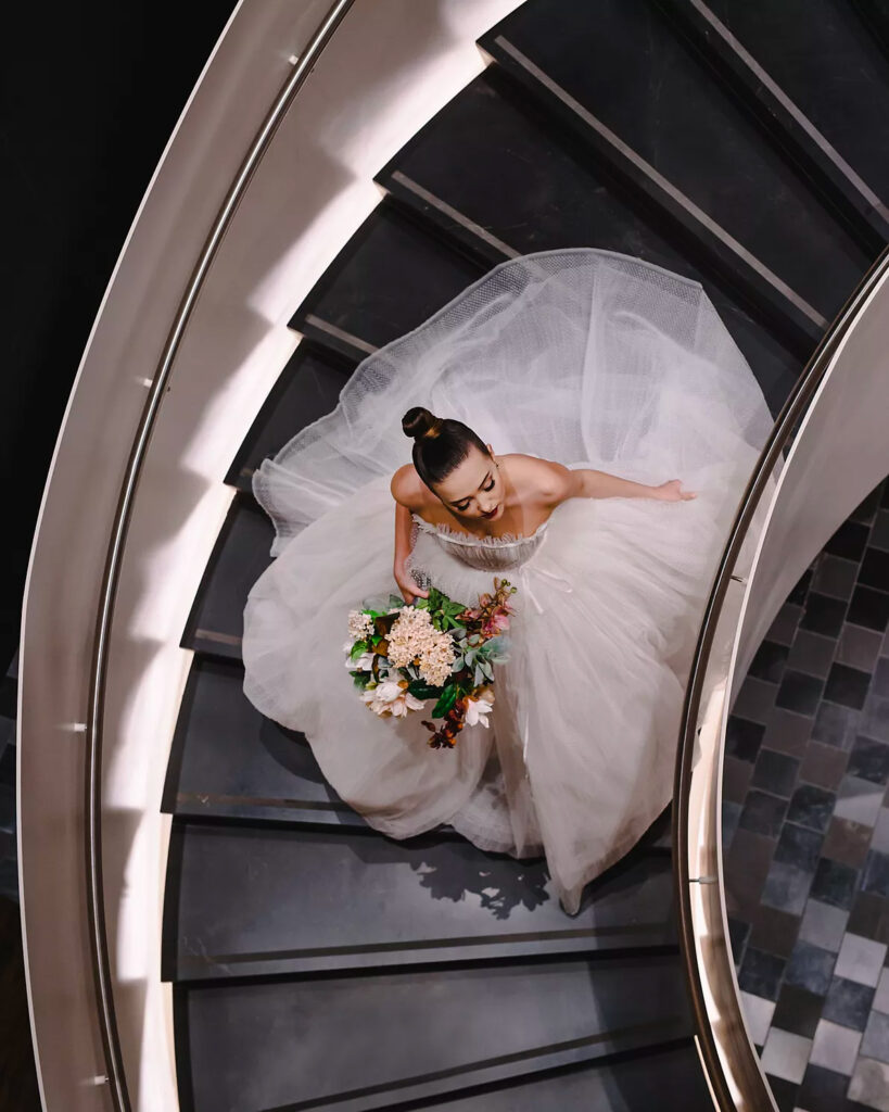 Couple de mariés photographié dans l'escalier du Fairmont Reine Elizabeth