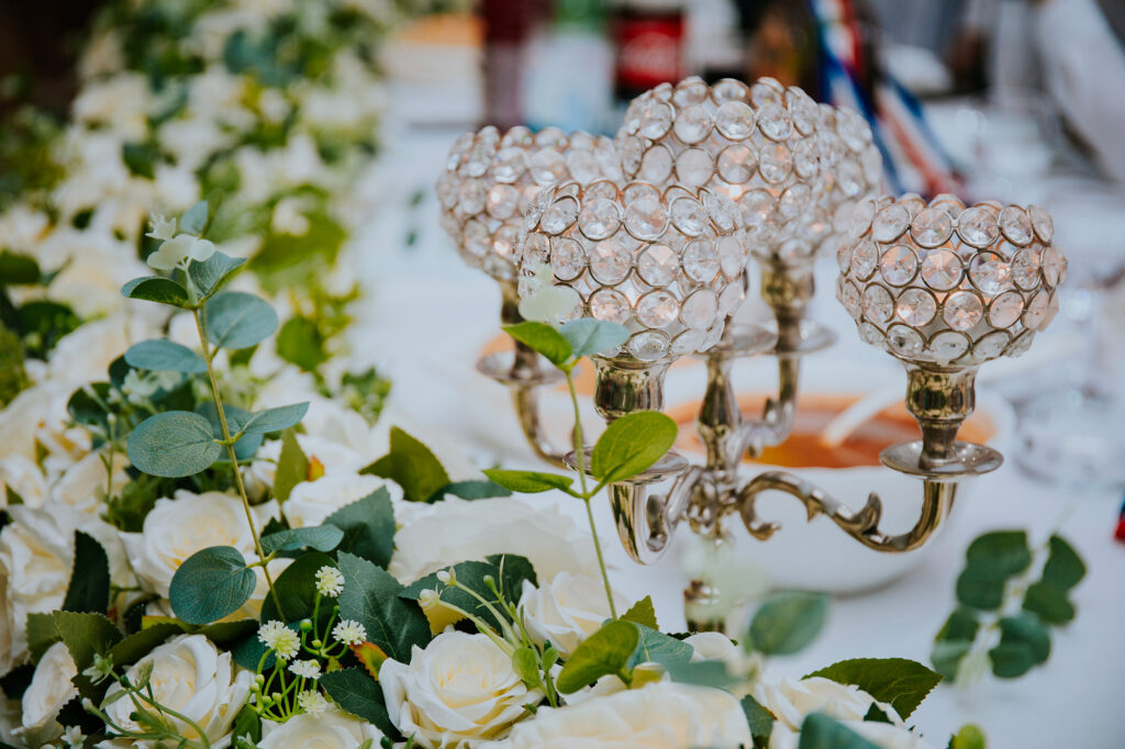 Cristaux suspendus et roses blanches dans une décoration de mariage élégante