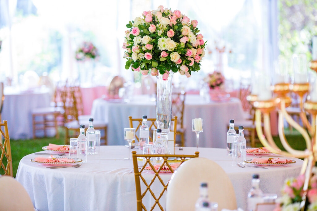 Décor de réception lumineux avec haut centre de table fleuri et vaisselle rose