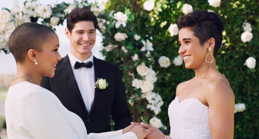 Couple échangeant ses voeux devant une officiant lors d'une cérémonie extérieure