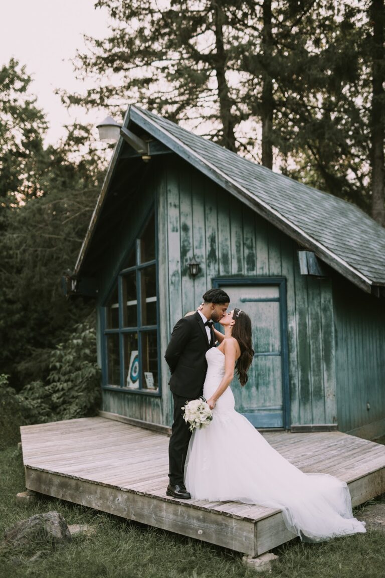 Baiser des mariés devant un petit chalet, photo de HBZ Photography
