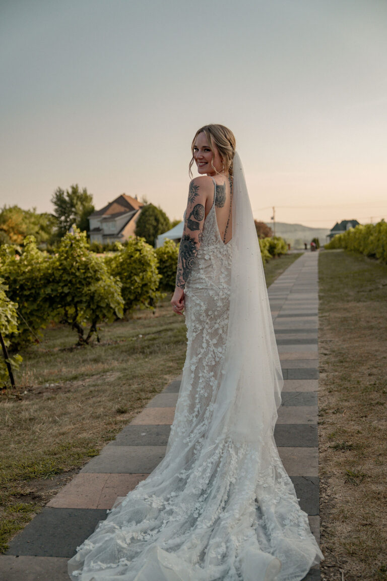 La mariée marche entre les vignes au soleil couchant